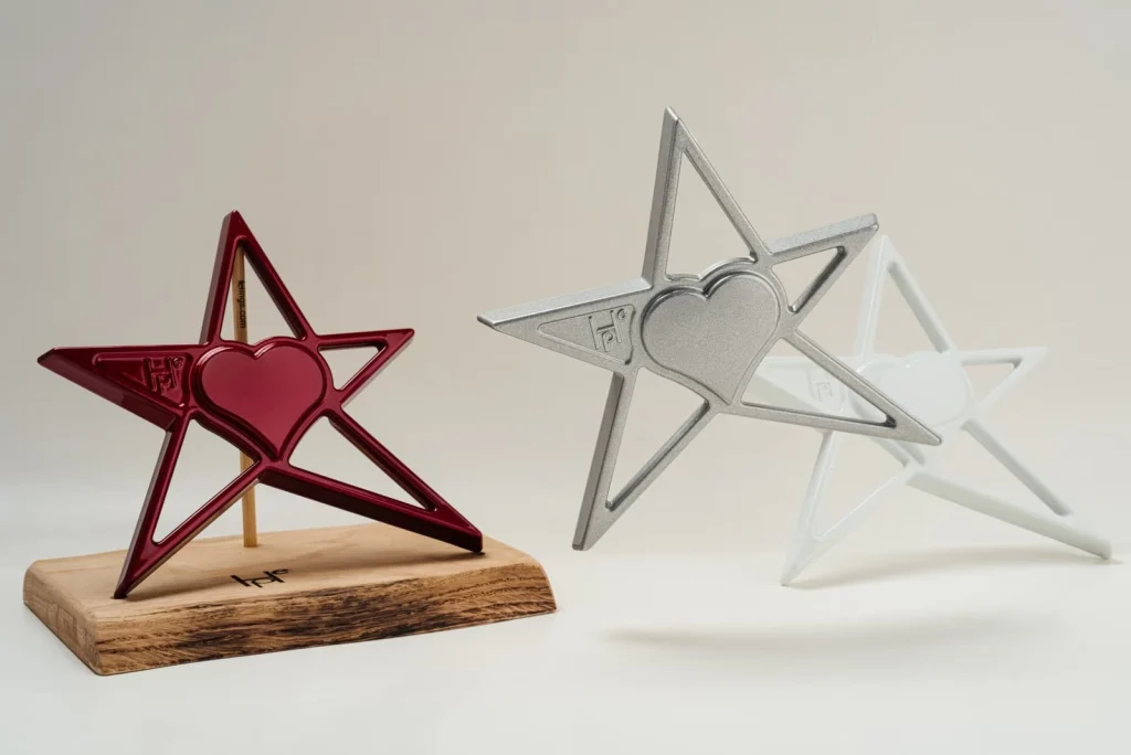 Tre stelle HOPE, rossa, argento e bianca, su una base in rovere